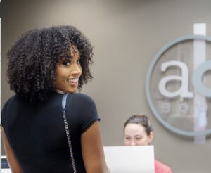 smiling woman with curly hair at AesthetiCare