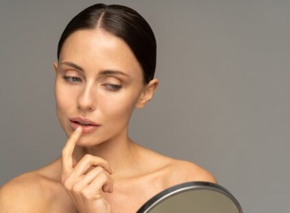woman with mirror wondering when is the best time to get laser treatment