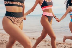 three women in swimsuits with glowing body skin