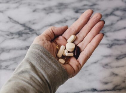 hand holding the top vitamins to take for wellness
