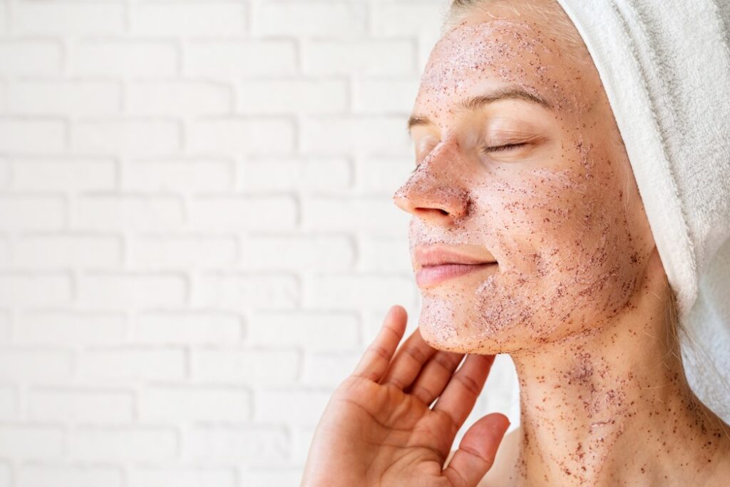 woman using facial scrub to reduce skin redness
