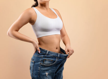 woman showing weight loss progress
