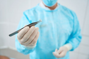 doctor in scrubs holding hormone pellet